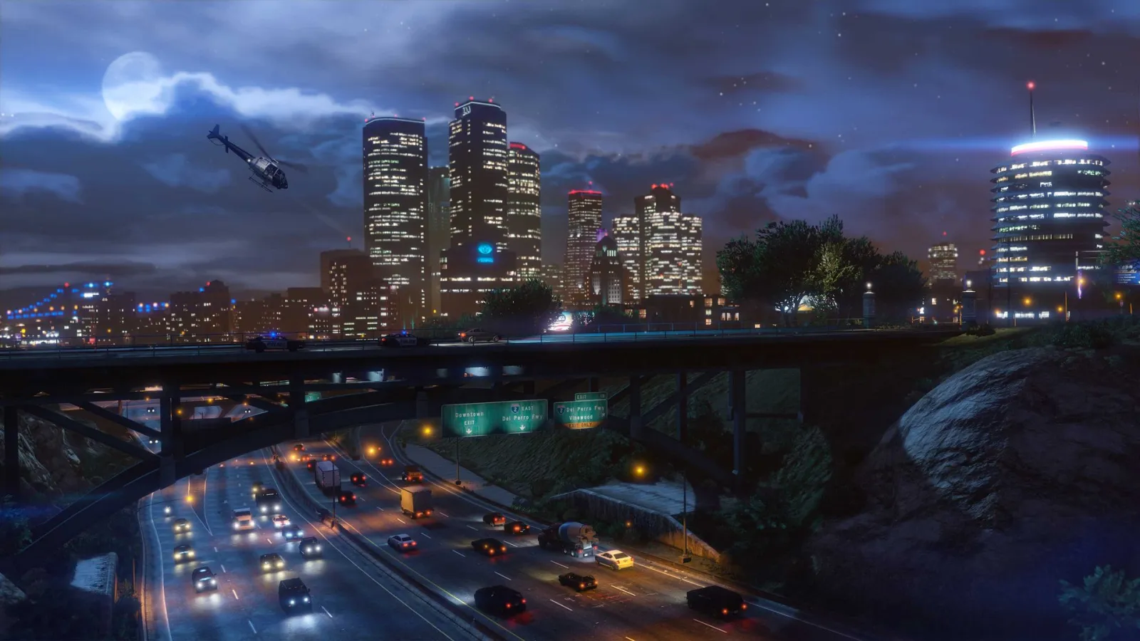 Los Santos de noche con rascacielos, autopista y un helicóptero en el cielo en GTA Online