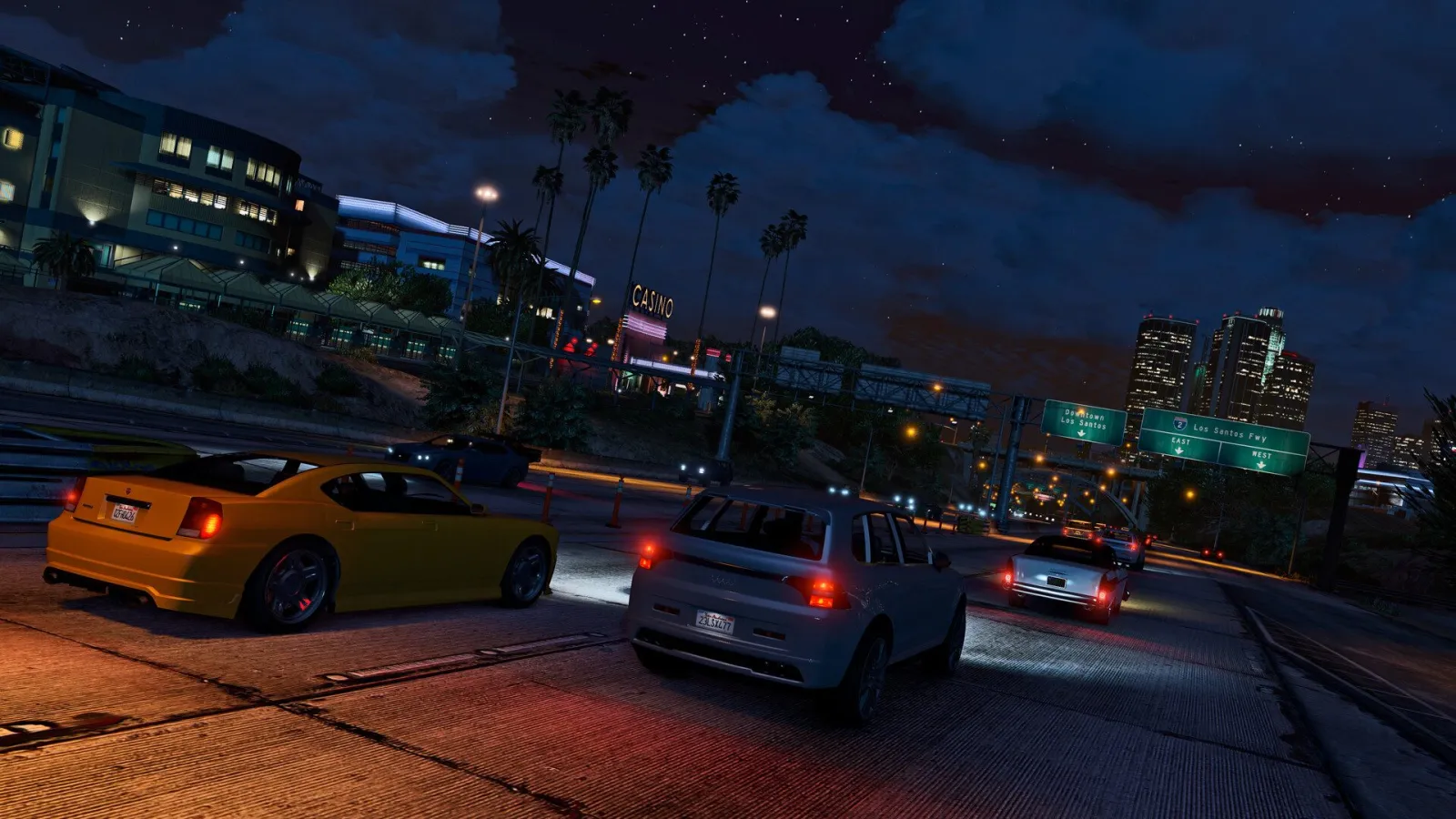 Машини на нічній автостраді з вогнями міста в GTA 5 Enhanced
